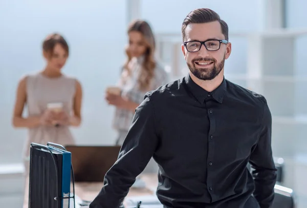 Sorridente giovane uomo d'affari in piedi in ufficio — Foto Stock