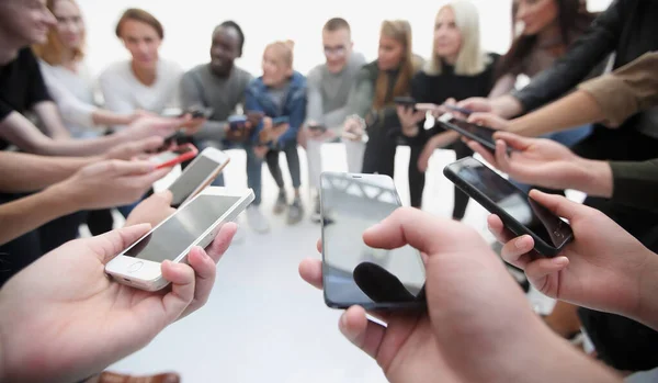 Gruppen junger Menschen lesen Nachrichten auf ihren Smartphones — Stockfoto