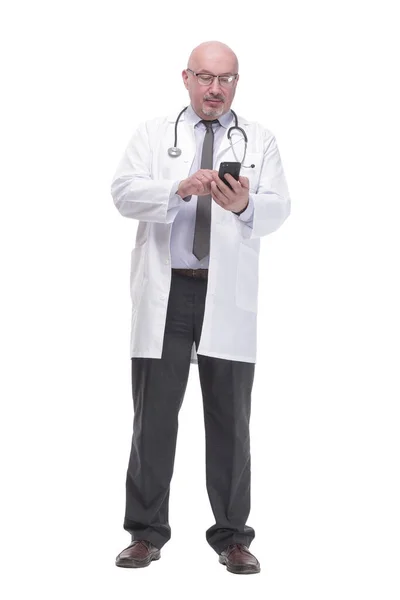 Mature doctor with smartphone. isolated on a white background. — стоковое фото