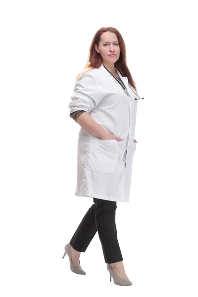 Mature woman doctor striding forward. isolated on a white background. — Zdjęcie stockowe