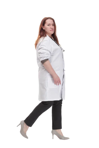 Mature woman doctor striding forward. isolated on a white background. — Stockfoto