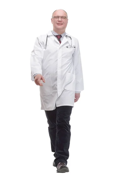 Зрелый доктор в белом халате шагает вперед — стоковое фото