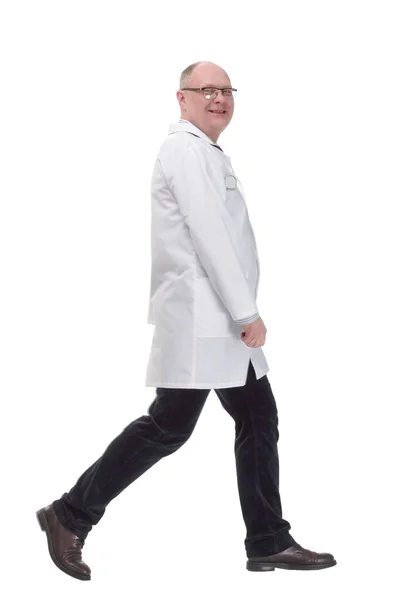 Зрелый доктор в белом халате шагает вперед — стоковое фото