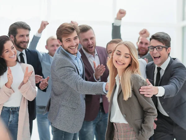 Grupo empresarial de empregados aplaudindo um jovem colega — Fotografia de Stock