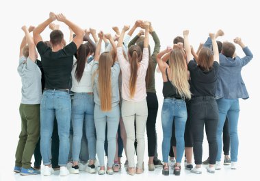 Bir grup genç insan ellerini kaldırarak ayakta duruyor.