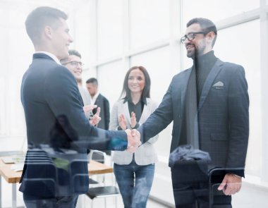 İşadamları anlaşmayı el sıkışarak onaylıyorlar..