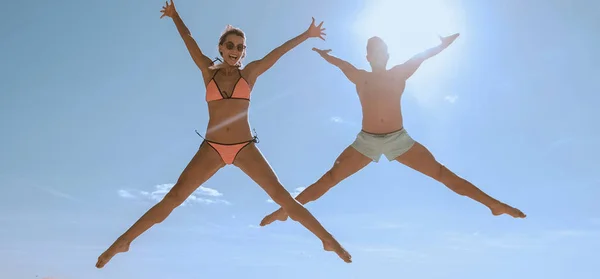 Bild eines glücklichen Paares, das am Strand springt. — Stockfoto
