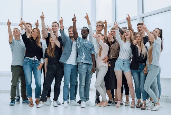 Група щасливих молодих людей, що вказують вгору — стокове фото
