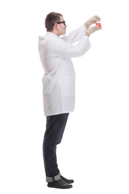 Side view of chemist holding up beaker of red chemical in the laboratory