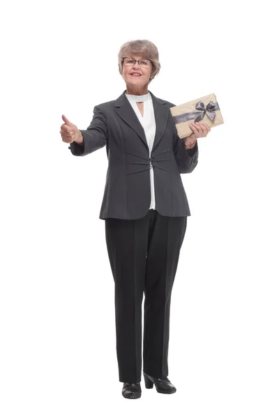 Full body senior woman happy and smiling, holding a gift and pointed on it — Stock Fotó