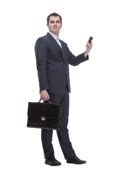 Pohledný mladý obchodní muž mluví na mobilním telefonu a drží kufr na bílém pozadí — Stock fotografie