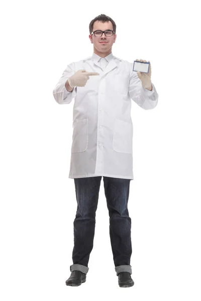Jovem médico segurando cartão em branco de negócios e sorrindo para a câmera — Fotografia de Stock