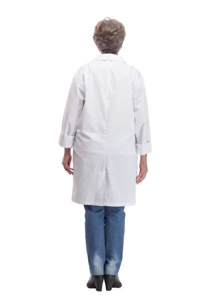 Full length profile studio shot of mature woman doctor in white coat and glasses walking — Stockfoto