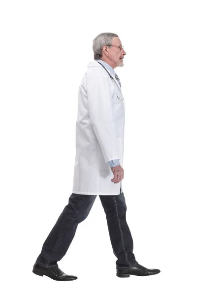 Senior doctor with stethoscope walking on white background — Stockfoto