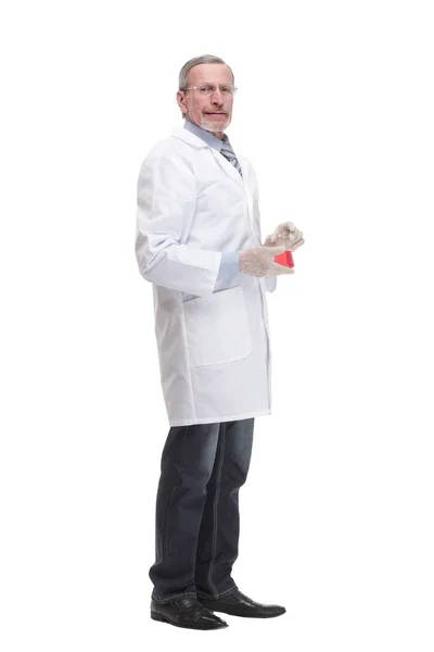 Portrait of a doctor wearing glasses and rubber gloves holding laboratory glassware beaker with red liquid substance — Stock Fotó