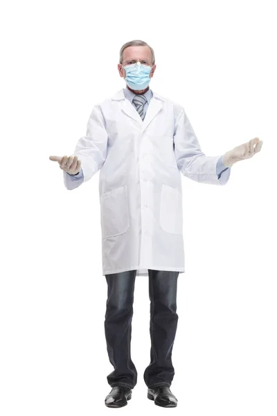Full lenth of a doctor in uniform, on a white background pulls a glove on his arm — Photo