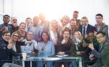 Başarılı iş adamları. Başparmakları havada, gülümsüyor, oturuyorlar.