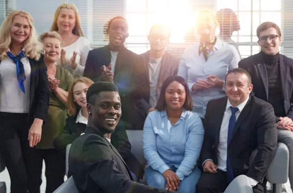 Bedrijfsleiders met een groep medewerkers die naar de camera kijken — Stockfoto