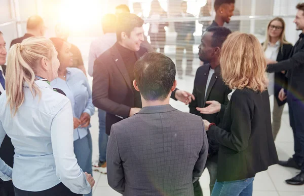 Empleados discutiendo temas de trabajo de pie en la oficina . — Foto de Stock