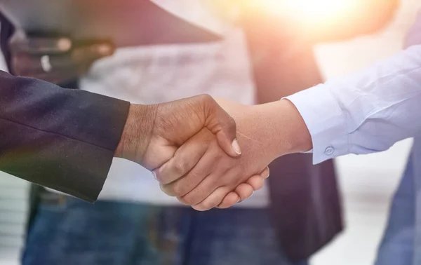 Närbild av handslag av affärspartners på bakgrund av emplo — Stockfoto