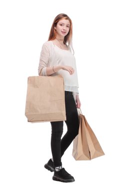 Stüdyo fotoğrafında güzel bir kadın yürüyor, kağıt alışveriş torbaları taşıyor.