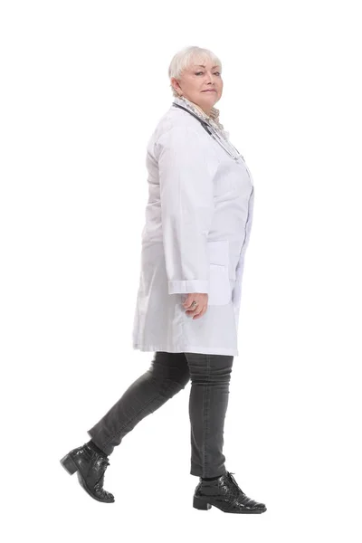 Estúdio vista lateral tiro de bela mulher madura no casaco branco andando — Fotografia de Stock
