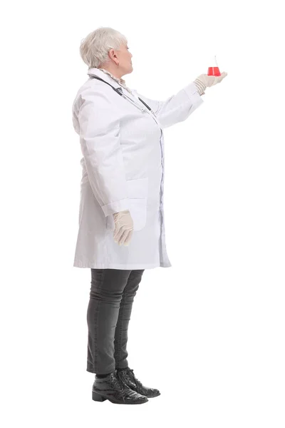 Вид збоку на жінку-хіміка в білому пальто з кольоровими розчинами в колбах в руках — стокове фото