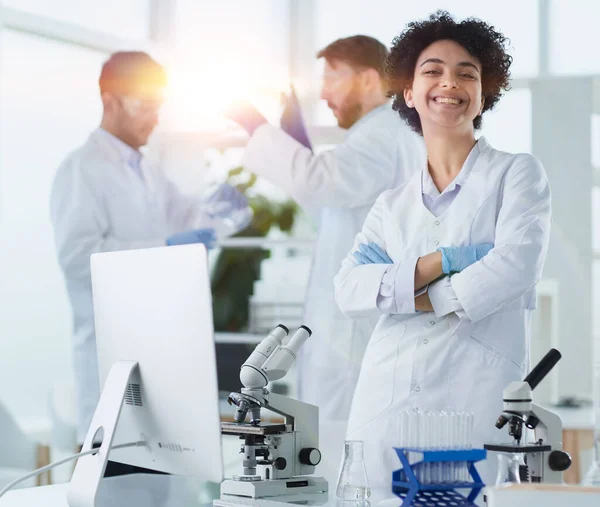 Científicos sonrientes mirando brazos de cámara cruzados en laboratorio — Foto de Stock