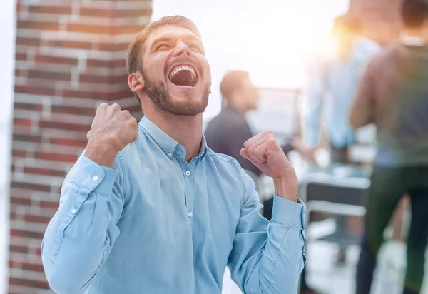 Hombre de negocios guapo celebrando la victoria gritando felizmente en th — Foto de Stock