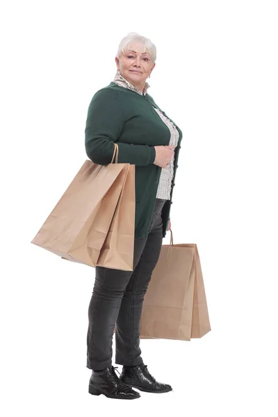 Улыбающаяся пожилая женщина с пакетами покупок на белом фоне — стоковое фото