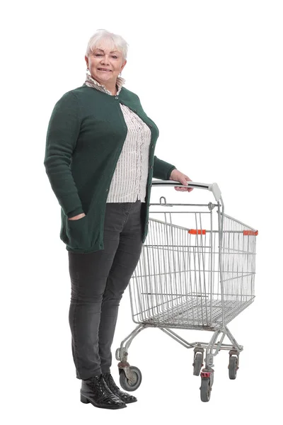 Full length profil záběr starší ženy stojící s prázdným nákupním vozíkem — Stock fotografie