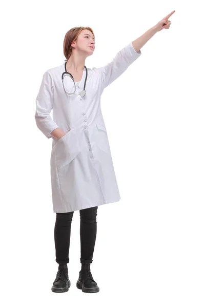 Mujer doctora con estetoscopio apuntando con el dedo hacia un lado y presentando un producto mientras sonríe en una pose segura —  Fotos de Stock