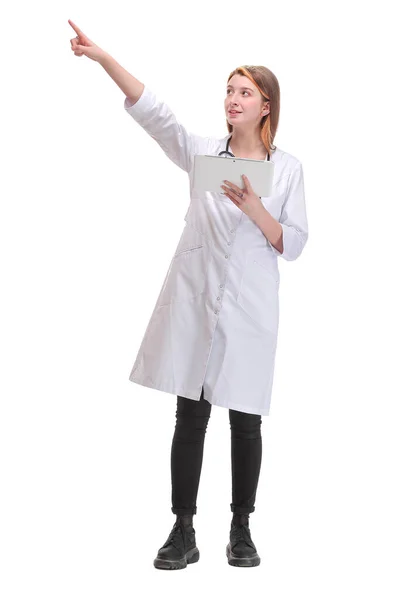 Vážný mladý lékař v laboratorním plášti drží tabletu a ukazuje na bílé pozadí — Stock fotografie