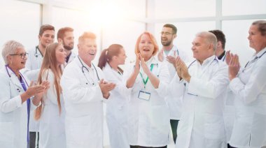 Bir grup farklı gülümseyen doktor alkışlıyor..