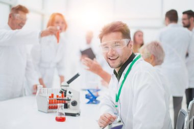 Test sonuçlarıyla birlikte test tüpüne bakan genç bir bilim adamı.