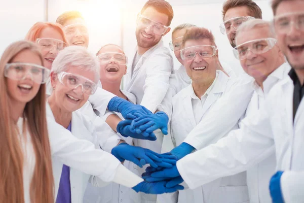 Grupa pracowników laboratorium medycznego łączących swoje dłonie. — Zdjęcie stockowe
