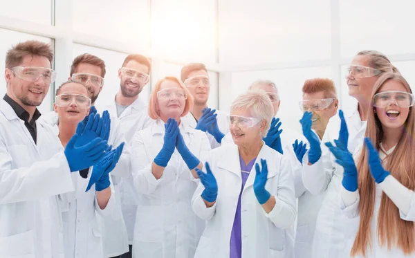 Большая группа медицинских исследователей аплодирует вместе. — стоковое фото
