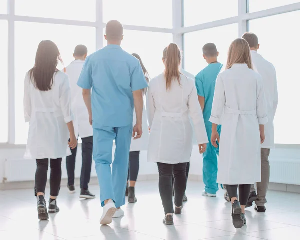 Vista trasera. médicos del centro médico caminando por el pasillo —  Fotos de Stock