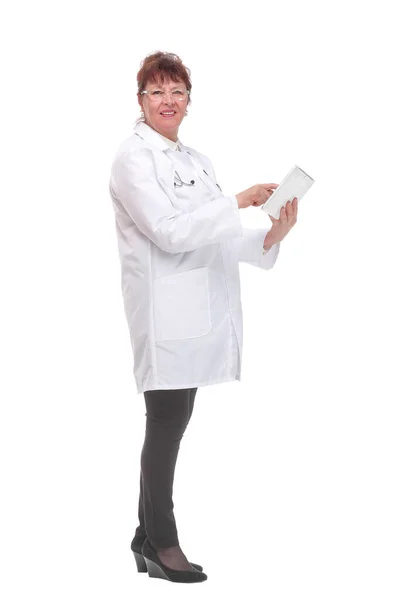 Steteskoplu yaşlı kadın doktorun yan görüntüsü. Tablete yazıp kameraya bakıyor. — Stok fotoğraf