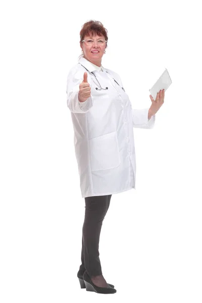 Side view of senior woman doctor with stethoscope write on tablet looking at camera — Stock Photo, Image