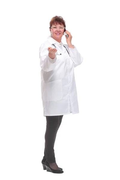 Side view of cheerful mature woman doctor standing and using smartphone — Stock Photo, Image