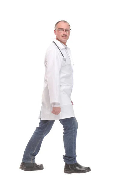 Médico de meia idade com estetoscópio andando sobre fundo branco — Fotografia de Stock