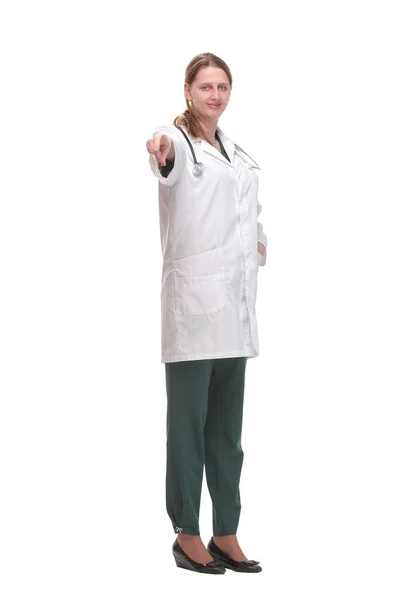 Glücklich lächelnde Ärztin zeigt vor weißem Hintergrund in die Kamera — Stockfoto