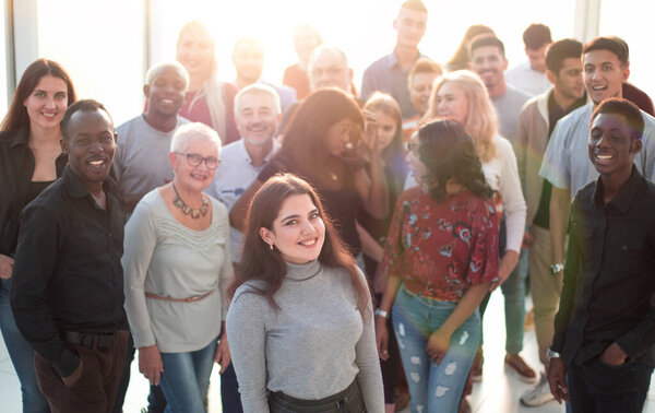 Young smiling executive standing in front of her business team