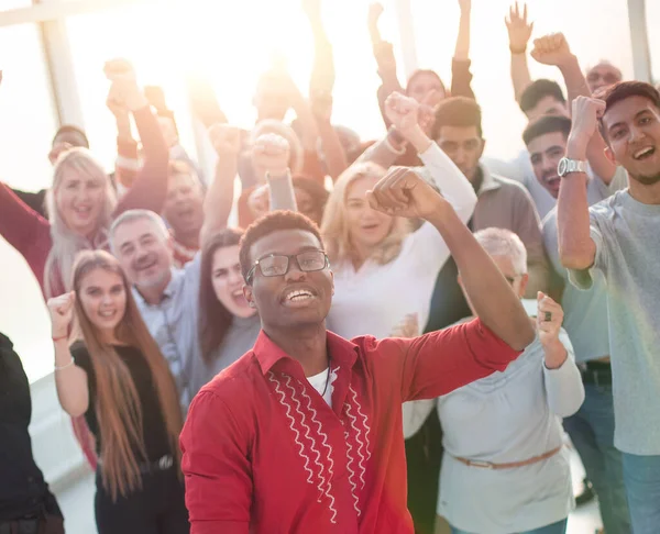 Multinationell grupp glada människor som står med händerna över huvudet. — Stockfoto