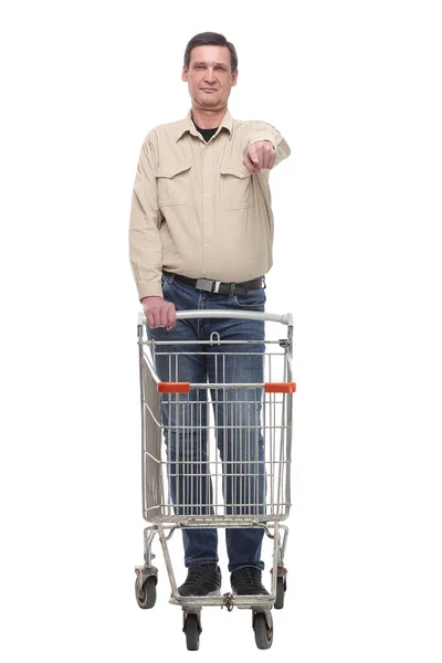 Retrato de comprimento total de um homem feliz andando com um carrinho de compras e apontando o dedo para a câmera — Fotografia de Stock