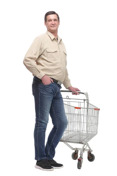 Pełna długość boku widok przystojnego młodego mężczyzny stojącego z wózkiem sklepowym — Zdjęcie stockowe