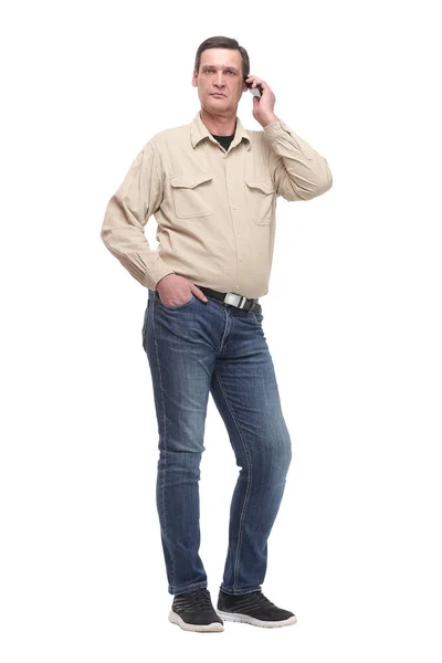 Hombre casual joven serio de pie con una mano en el bolsillo y hablando por teléfono —  Fotos de Stock