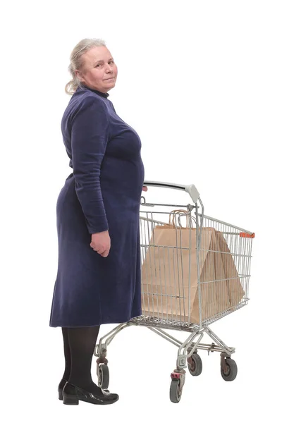 Visão traseira da mulher idosa fazendo compras no supermercado e empurrando um carrinho. — Fotografia de Stock