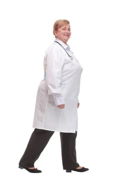 Typ av allvarlig läkare kvinna gå isolerad över vit studio — Stockfoto